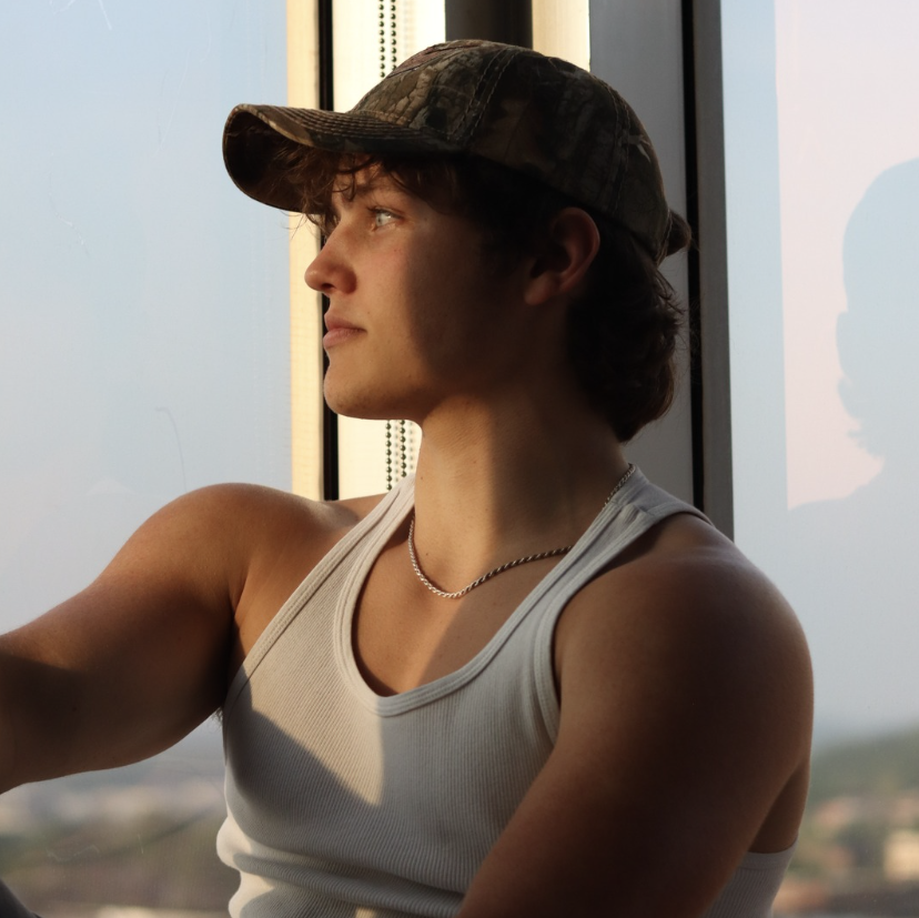 Adrian looking out over the city from a rooftop window